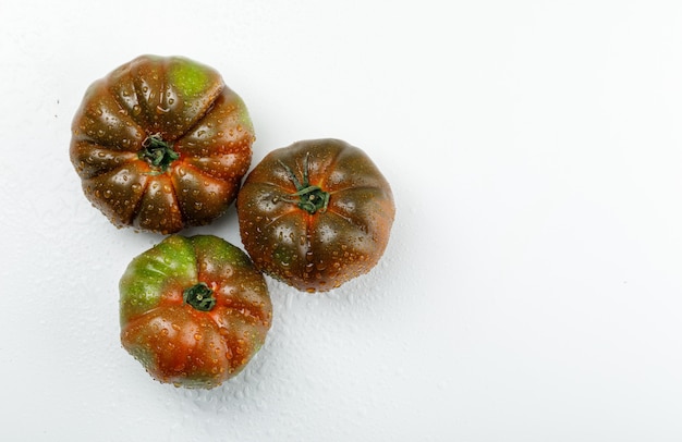 Kumato tomaten plat lag op een witte muur