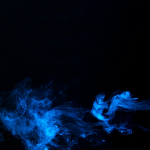 Kunst van heldere blauwe rook op zwarte achtergrond met exemplaarruimte