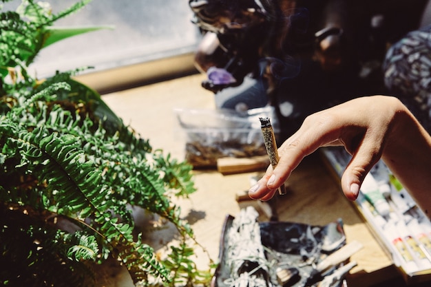 Gratis foto kunstenaar die marihuana rookt, pen en joint