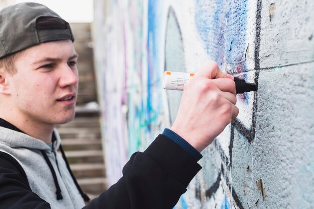 Kunstenaar die overzicht van graffiti op muur maakt