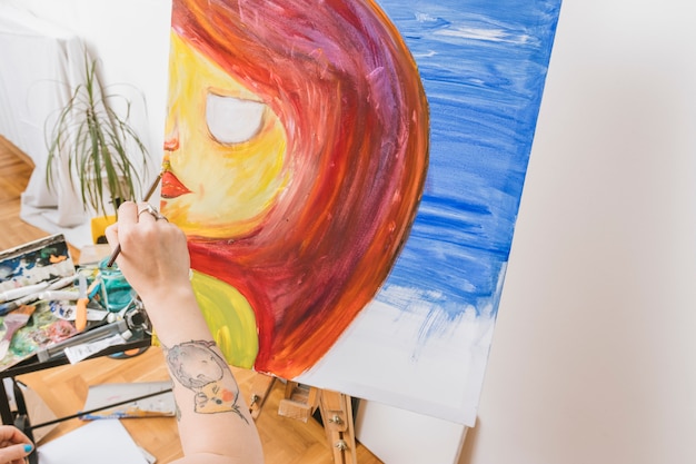 Kunstenaar die vrouw op schildersezel in workshop schildert