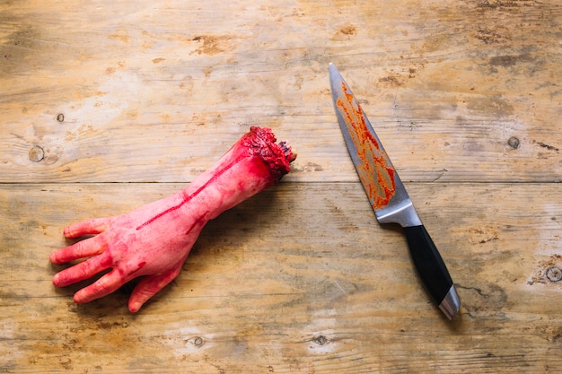 Gratis foto kunstmatig gesneden hand in bloed en mes