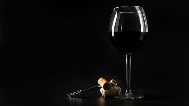 Kurkt en kurketrekker dichtbij glas wijn