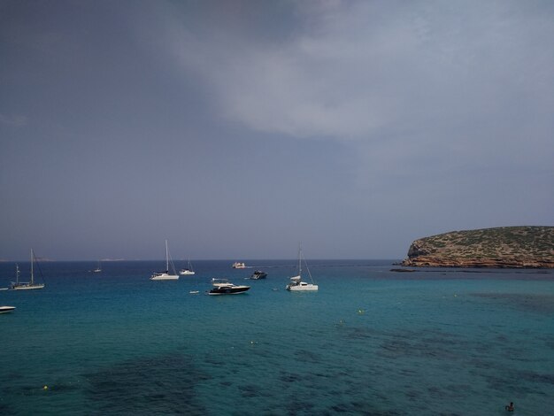 Kust naast Ibiza met een paar boten voor het stormachtige weer