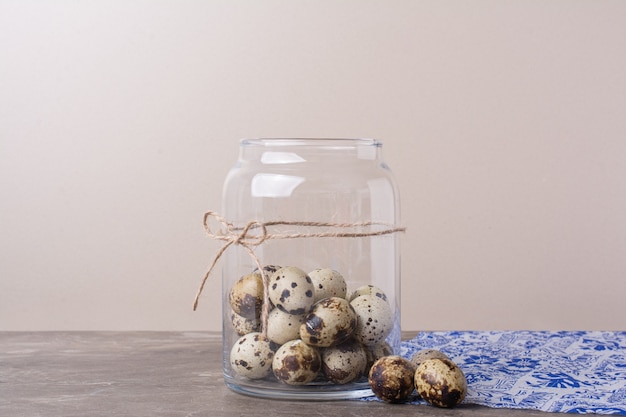 Kwarteleitjes in een kruikcontainer op de blauwe handdoek