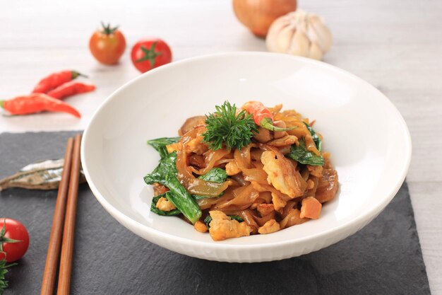 Kwetiau is populaire chinese noedels in indonesië, gekookt door frituren met groenten en kip, zeevruchten of vlees