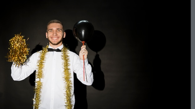 Lachen man in shirt met ballon en klatergoud