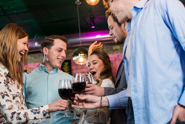 Lachen mannelijke en vrouwelijke vrienden in bar genieten van drankjes
