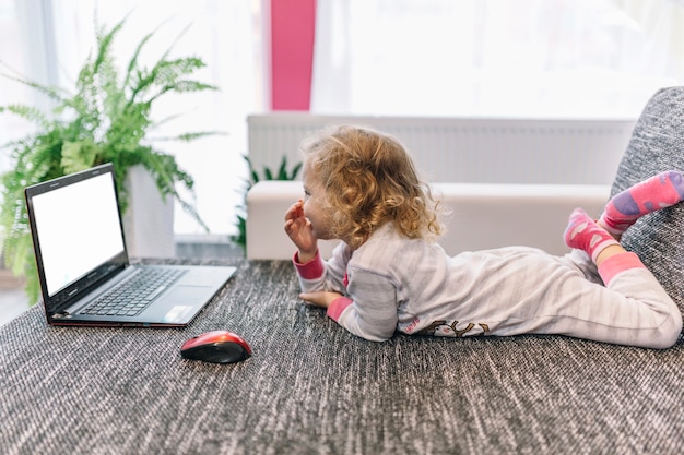 Lachend meisje dat laptop op laag met behulp van