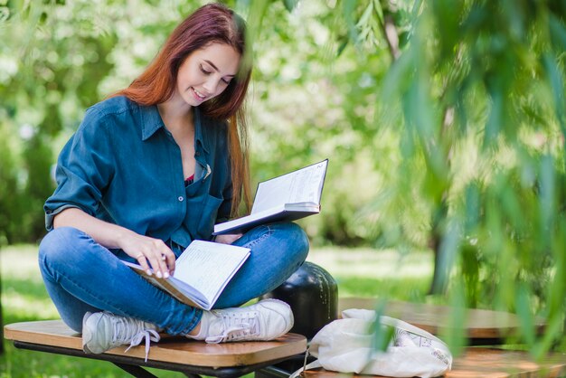 Lachend meisje in het park houden boek lezen