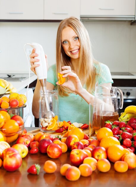 Lachend meisje maken fruit drankjes