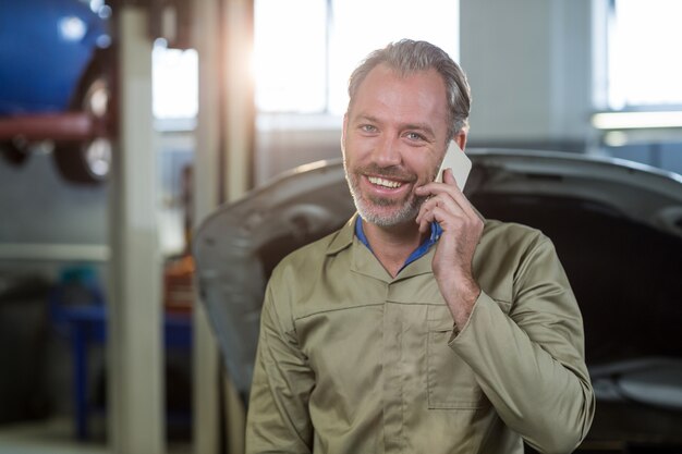 Lachend monteur praten over een mobiele telefoon