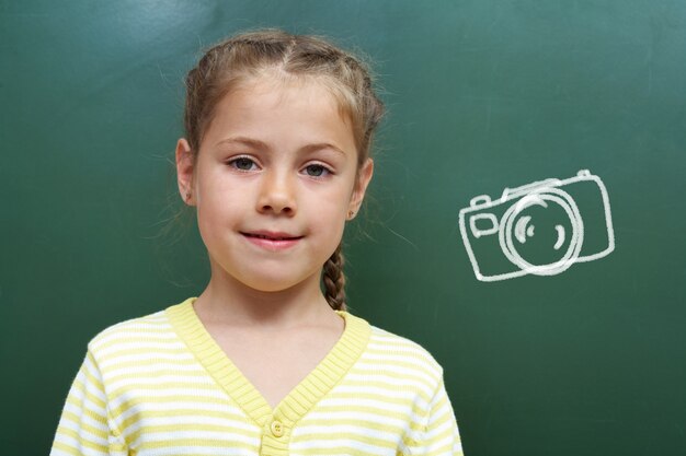 Gratis foto lachend student met een camera op het bord