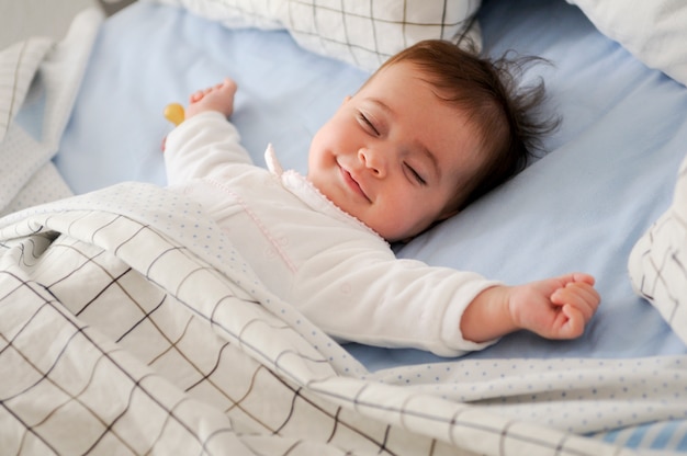 Lachende baby liggend op een bed