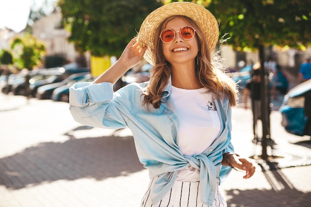 lachende blonde model in zomer kleding die zich voordeed op straat