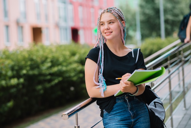 Lachende denken schoolmeisje met leerboek