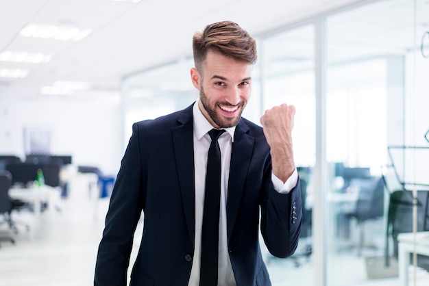 Gratis foto lachende elegante man met een vuist verhoogd