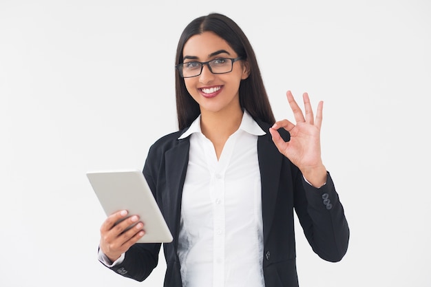 Lachende elegante vrouw met Tablet die OK teken toont