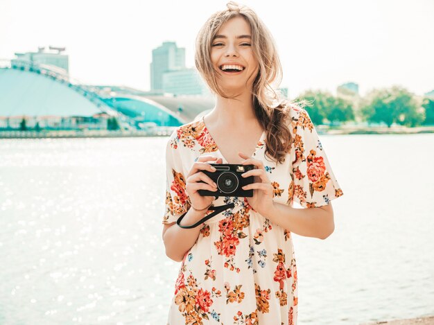 lachende hipster meisje in trendy zomer zonnejurk met retro camera