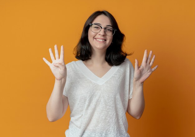 lachende jonge mooie vrouw draagt een bril met negen met handen