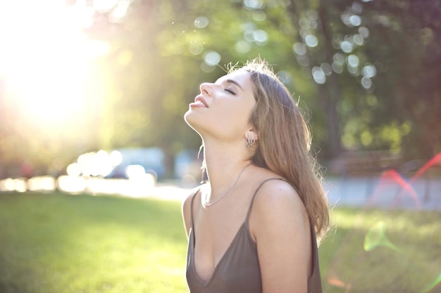 lachende jonge vrouw ademt frisse lucht in een park