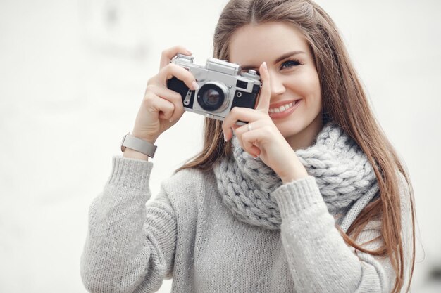 lachende jonge vrouw met fotocamera buiten