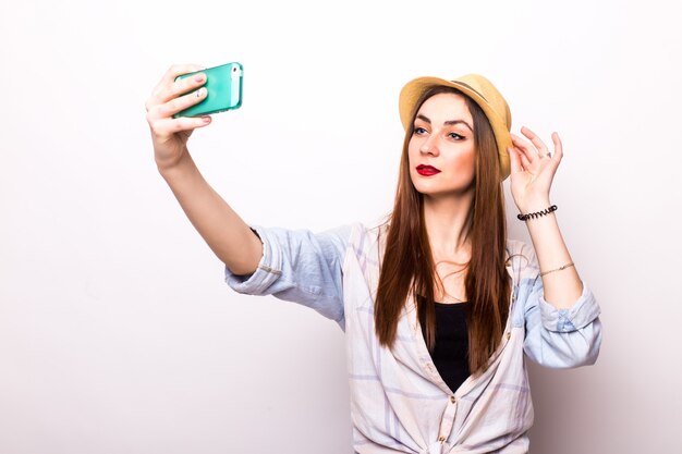 Lachende jonge vrouw selfie foto maken op smartphone over grijs