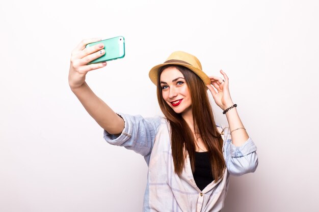 Lachende jonge vrouw selfie foto maken op smartphone over grijs