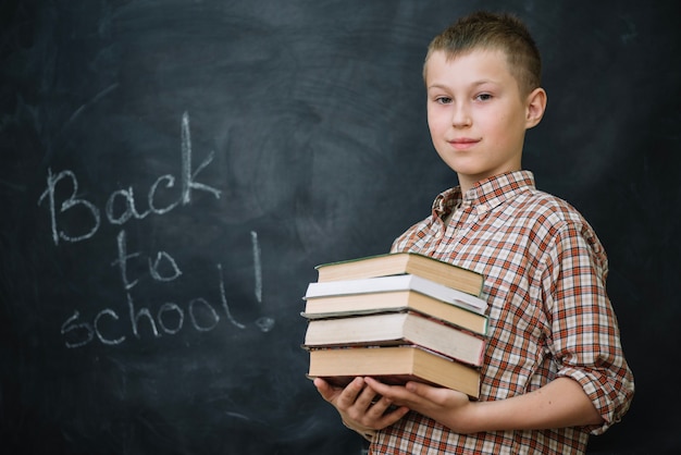 Lachende jongen die boeken houdt