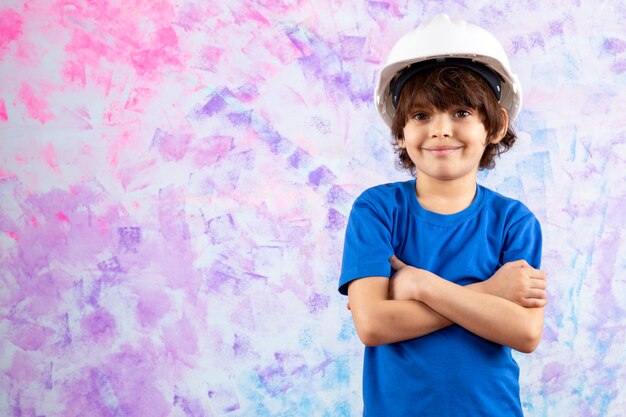 lachende jongen in blauw t-shirt en witte helm op veelkleurige