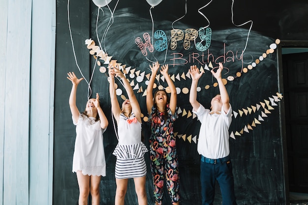 Lachende kinderen die ballonnen loslaten