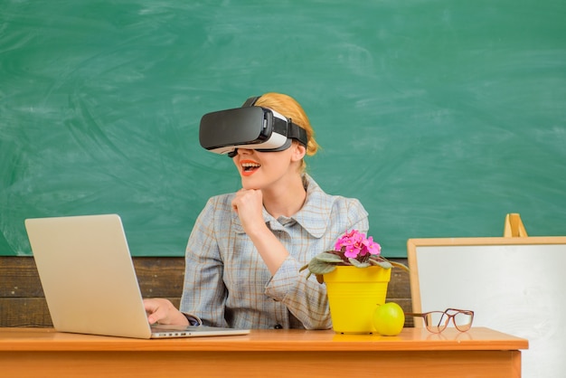 Lachende leraar in vr-headset terug naar school online onderwijsleraar met laptoponderwijsconcept