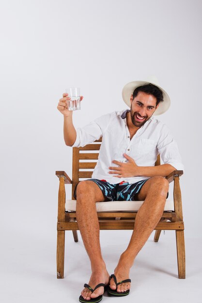 Lachende man in zomer slijtage met glas water