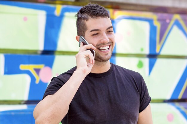 Lachende man te praten op zijn telefoon