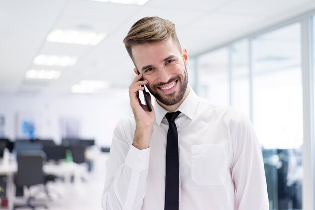 Lachende man te praten op zijn telefoon