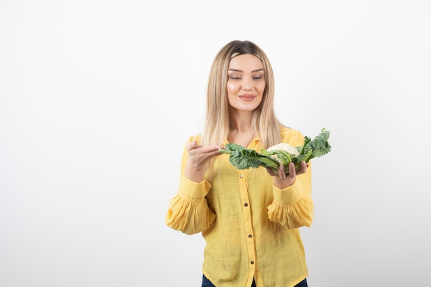 lachende mooie vrouw model permanent en bloemkool te houden.