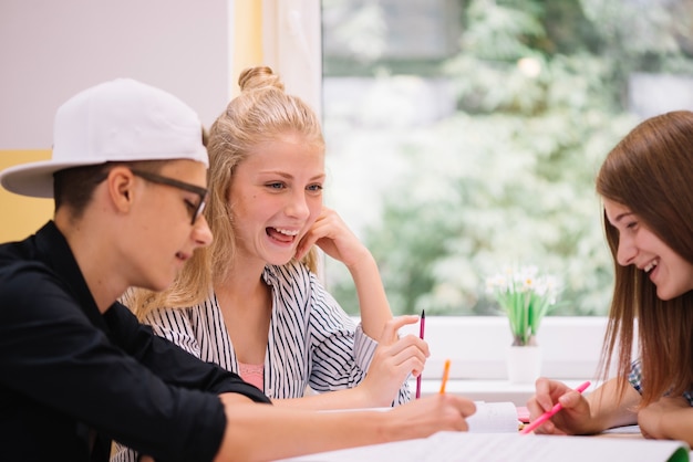 Lachende studenten studeren samen