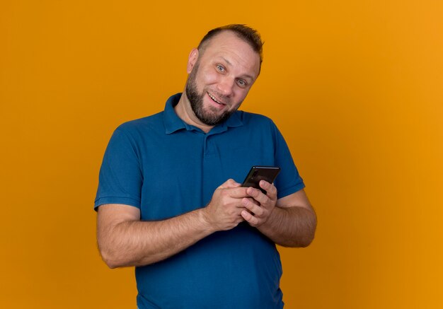 Lachende volwassen slavische man met mobiele telefoon op zoek