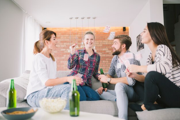 Lachende vrienden gooien met speelkaarten