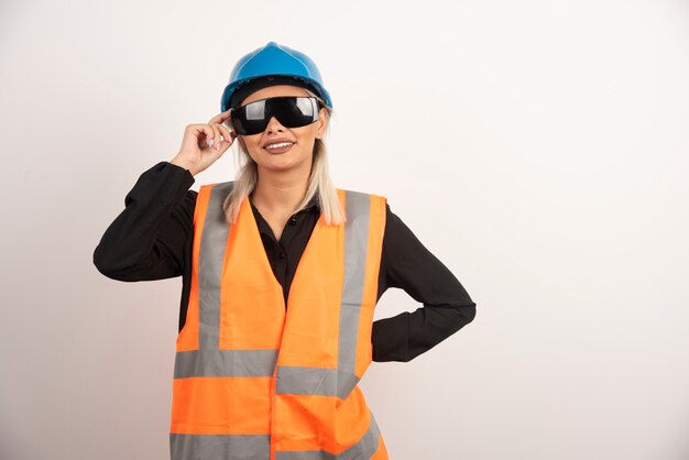 Lachende vrouw bouwer poseren met bril en helm. Hoge kwaliteit foto