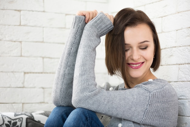 Gratis foto lachende vrouw die op muur leunt