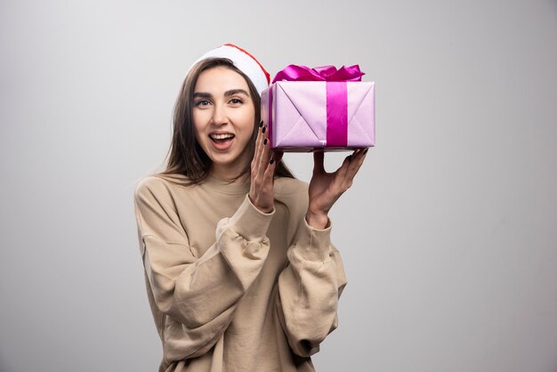 Lachende vrouw met een doos met kerstcadeautjes.