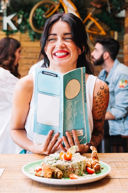 Lachende vrouw met gerecht en menu