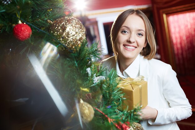 Lachende vrouw naast een kerstboom