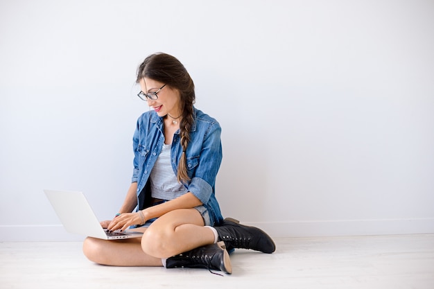 Lachende vrouw te typen op de laptop