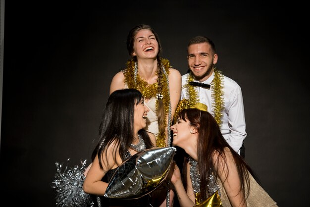 Gratis foto lachende vrouwen en man met ballon en klatergoud