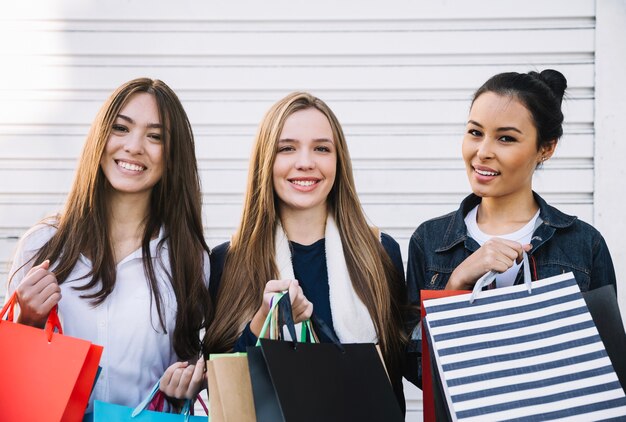 Lachende vrouwen poseren met zakken