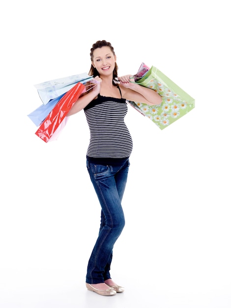 lachende zwangere vrouw met boodschappentassen