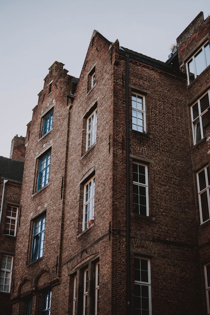 Lage hoek die van bruine baksteenarchitectuur is ontsproten met een witte hemel