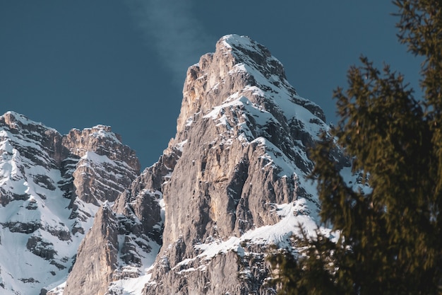 Lage hoek die van een deel van een bergketen met bomen eronder in de winter is ontsproten